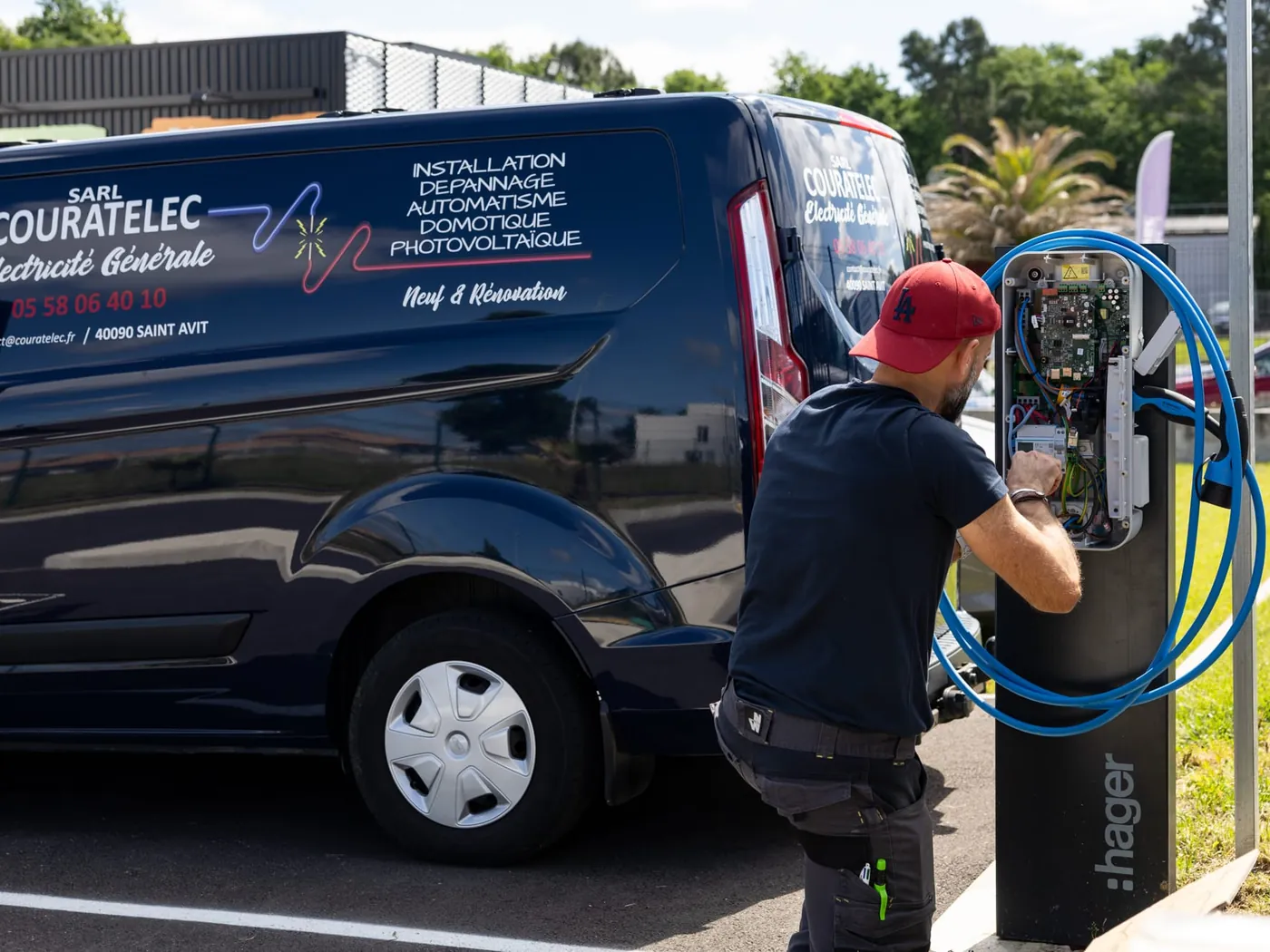 Technicien Couratelec posant une borne de recharge devant le camion de l’entreprise